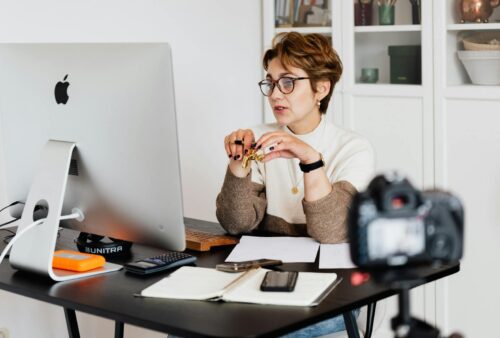 Confident elegant lady in eyeglasses hosting webinar