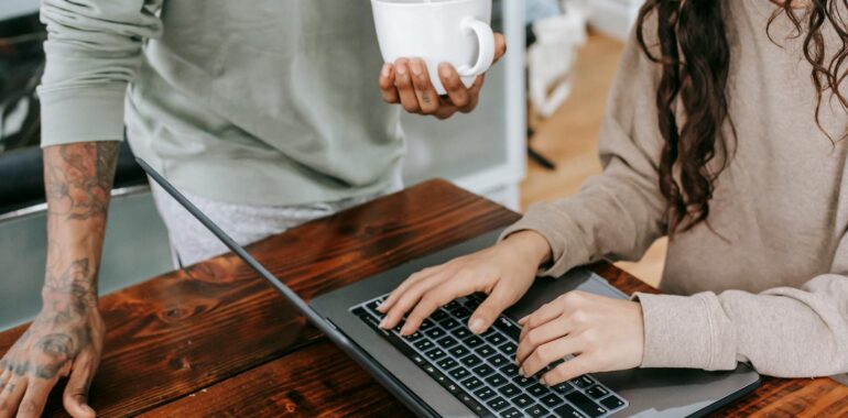 Woman In Brown Long Sleeve Shirt Using Macbook Pro