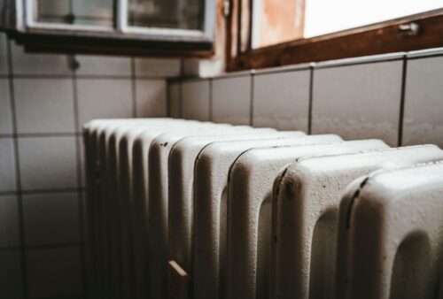 white radiator heater beside brown wooden window