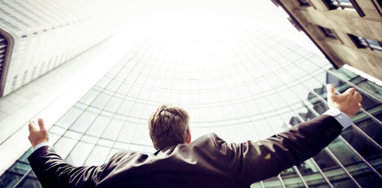 low-angle photography of man in the middle of buidligns