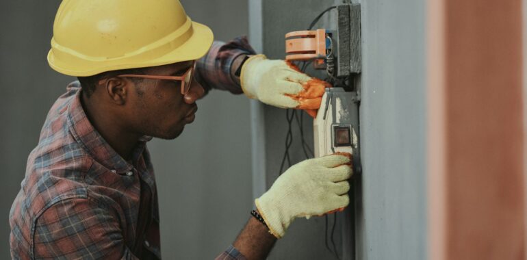 man in brown hat holding black and gray power tool