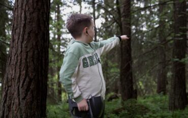 Boy with Metal Detector in Forest