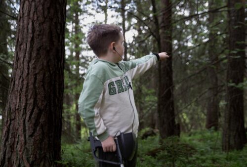 Boy with Metal Detector in Forest